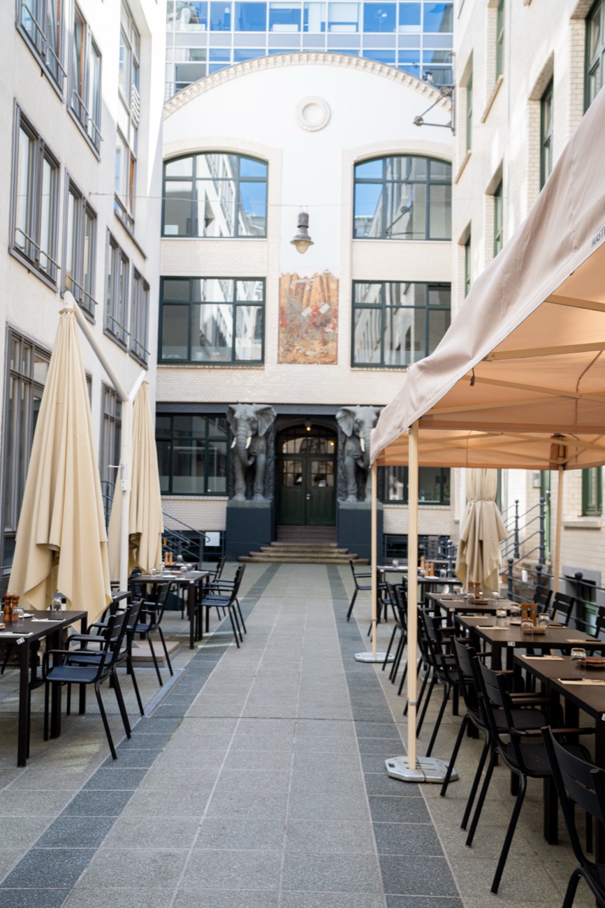 Sonniger Innenhof mit Terrassenbestuhlung von Estancia Steaks