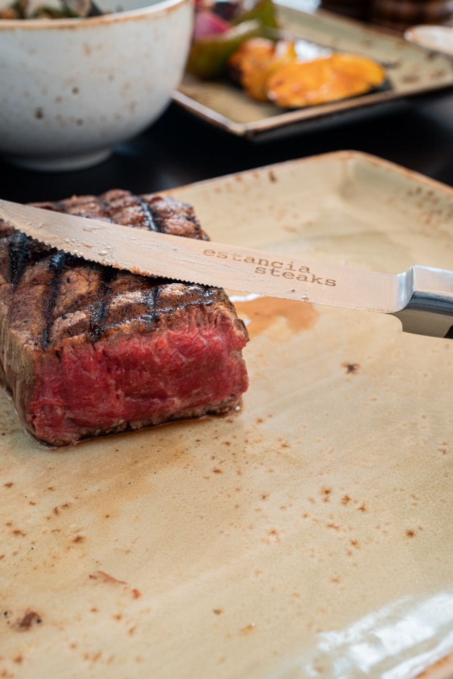Auf den Punkt gegrilltes Steak, angeschnitten, auf einem Estancia-Steaks-Teller mit Messer